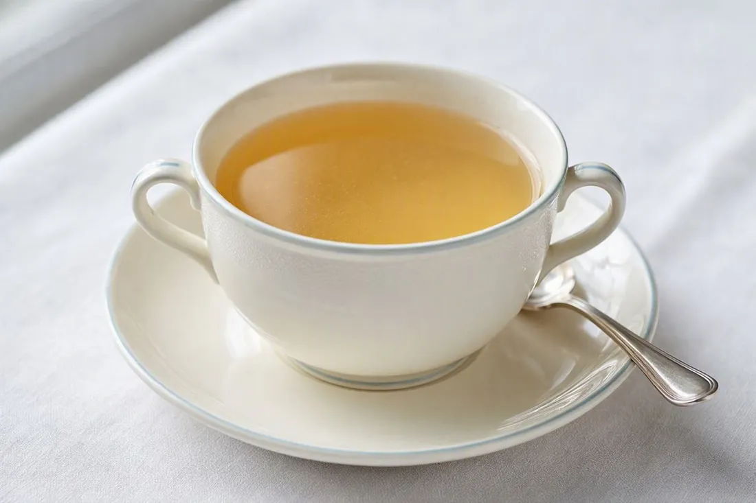 Clear, chilled beef consommé served in a bouillon cup with no garnish